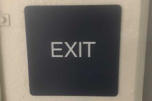tactile exit sign with braille text underneath