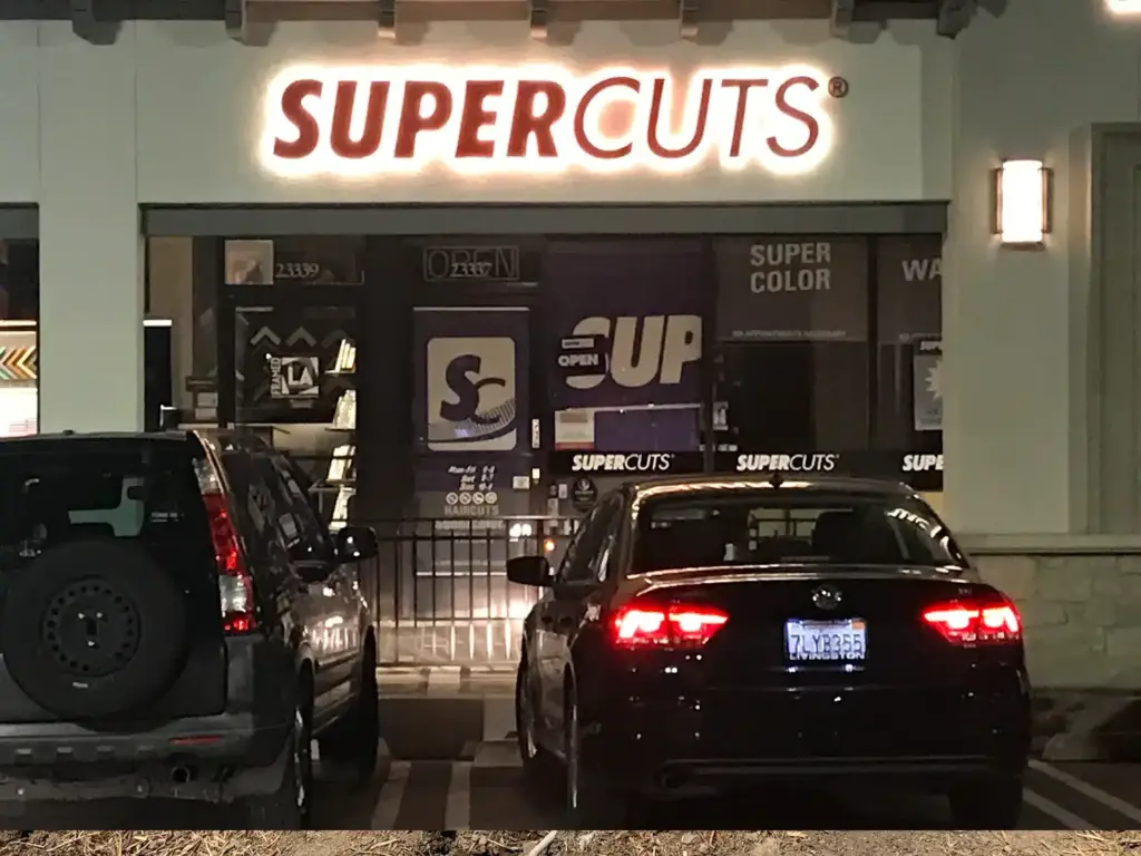 SuperCuts channel letter sign lit up at night