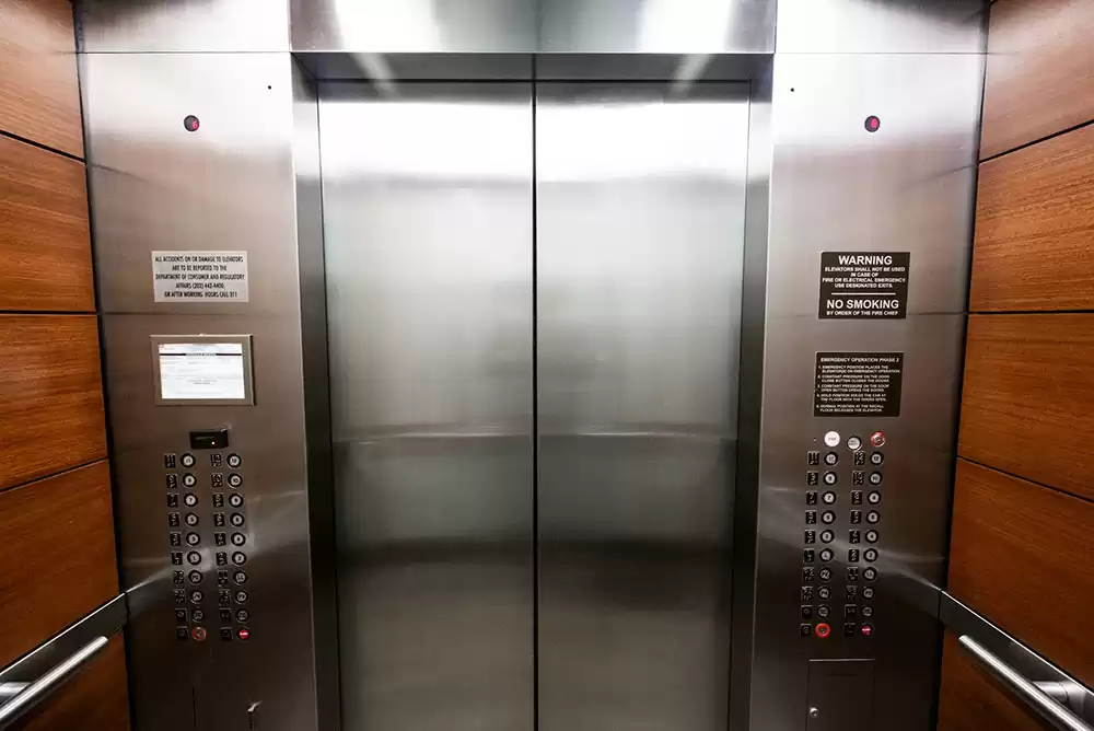 Stainless steel elevator with buttons.