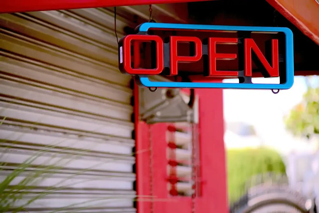 Red and blue neon “OPEN” sign hanging outside a storefront.